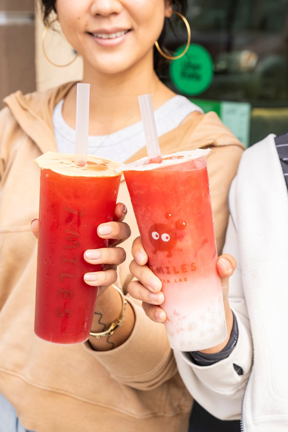 Two friends holding up 7 Miles drinks