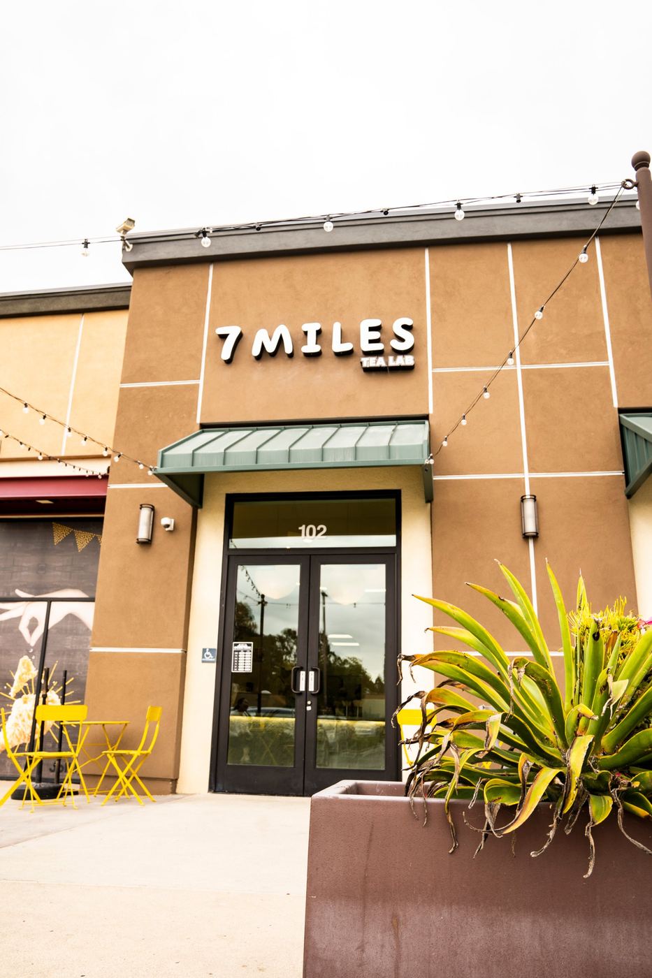 7 Miles Tea Lab storefront with string lights and patio chairs